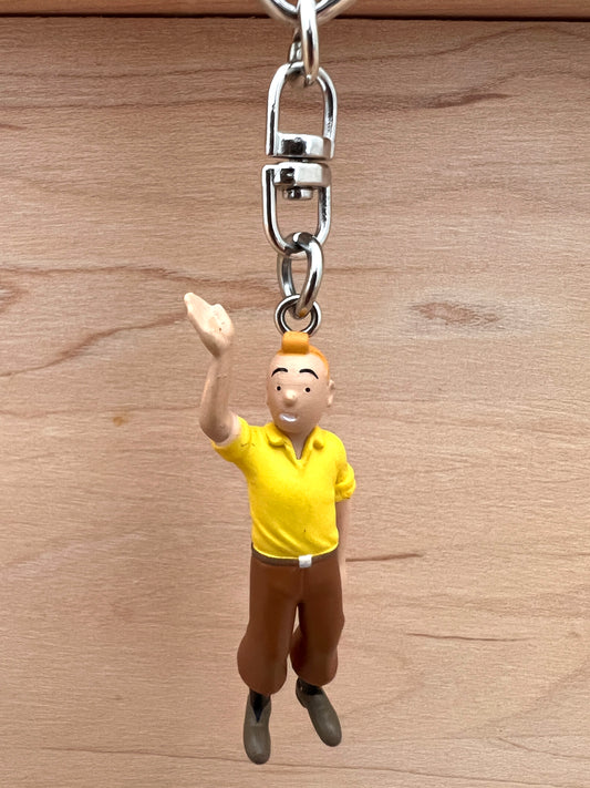 Tintin waving key chain.  PVC construction. Figure is 6cm (2.4") tall, overall length of the keychain is 10.5cm (4.1"). 